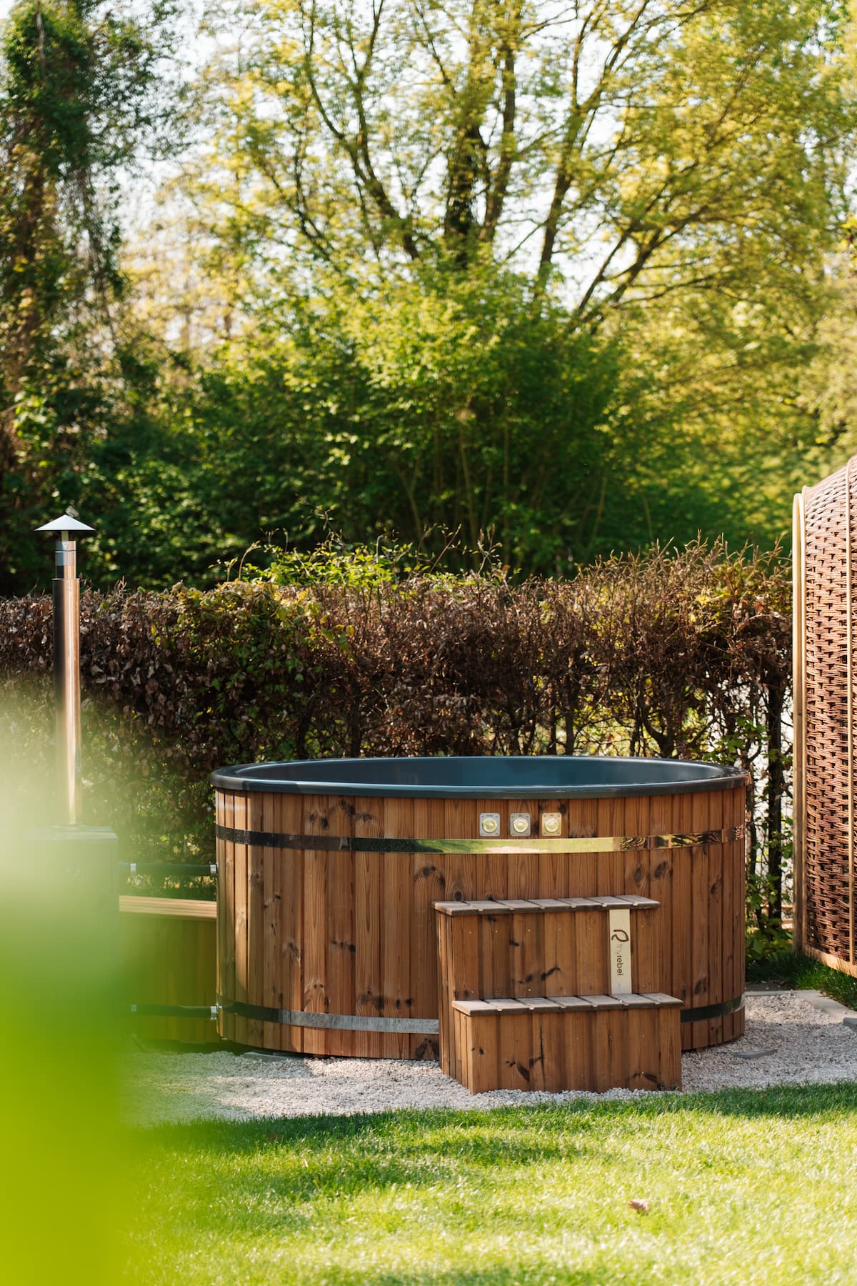 Hottub Vatten met een externe biodiesel kachel in groene omgeving.